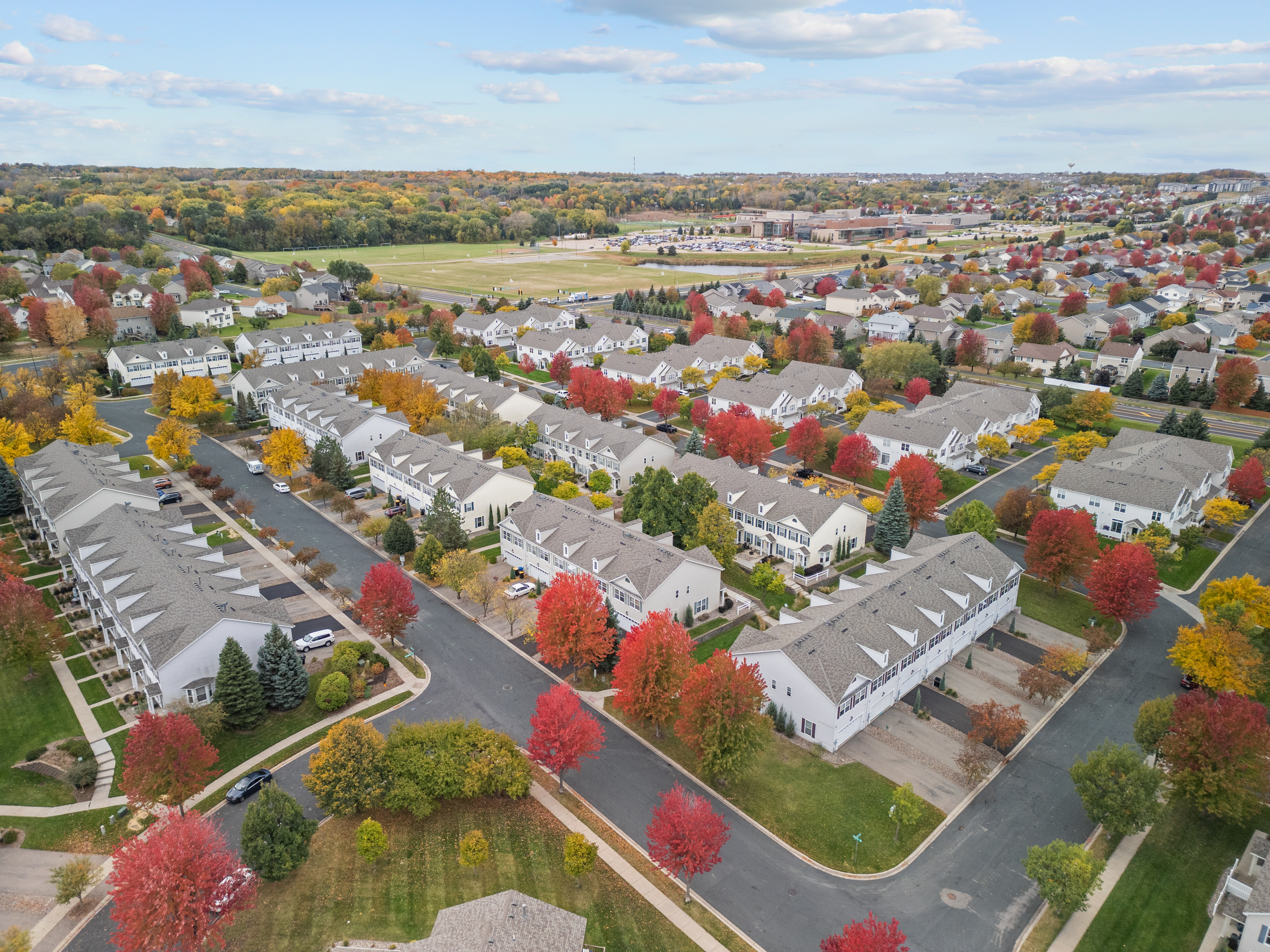 Aerial view of suburban neighborhood showcasing fall foliage and real estate properties.