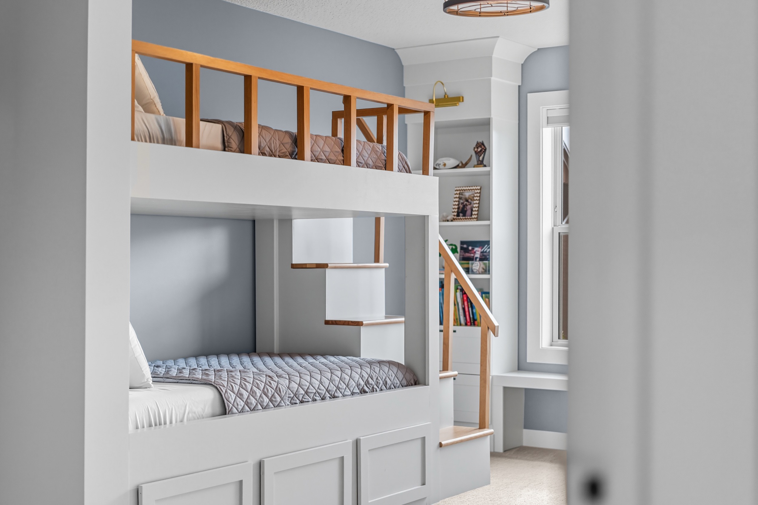 Modern bedroom interior with bunk beds and built-in storage, showcasing real estate photography services.