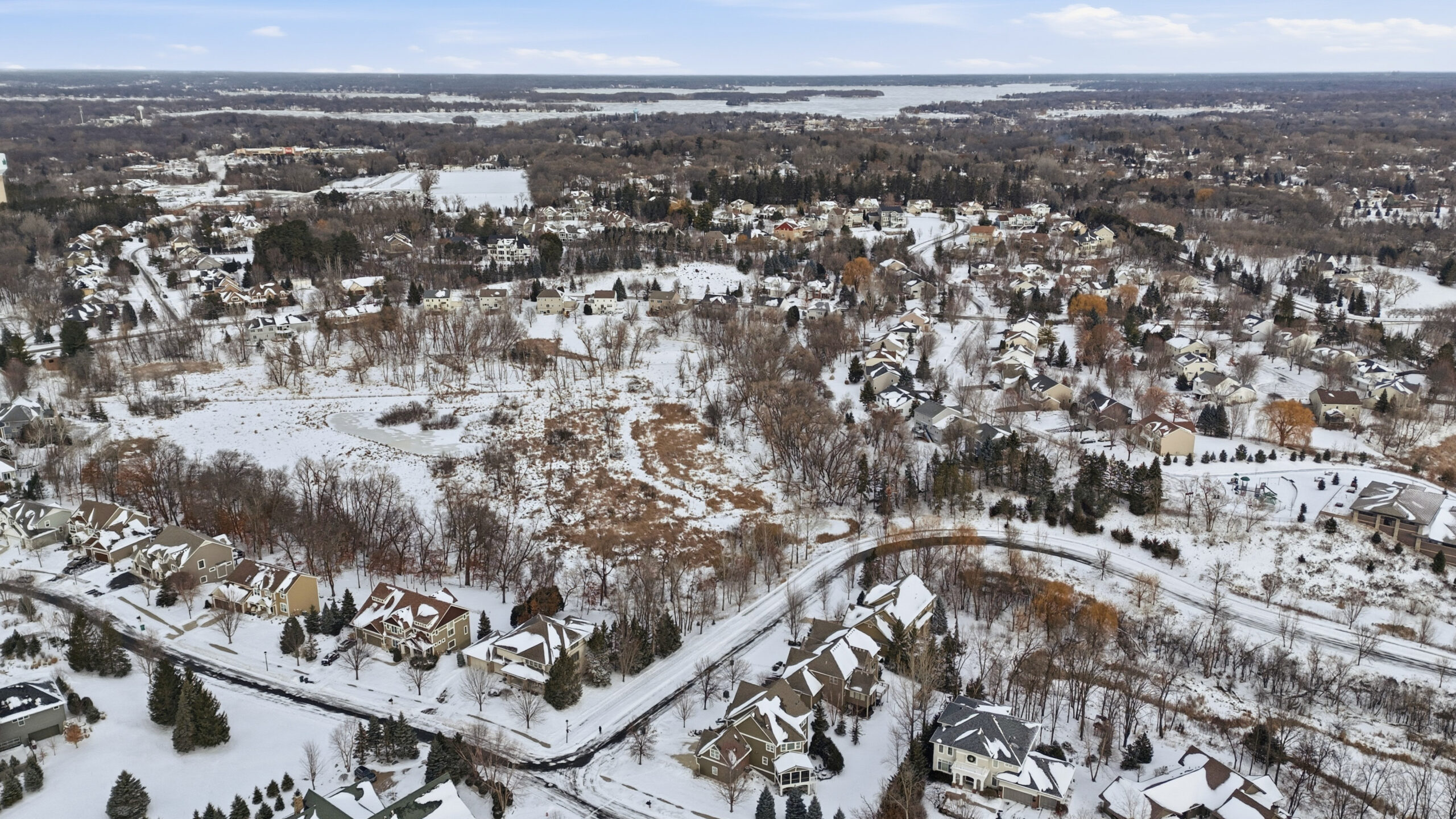 Aerial view of residential neighborhood and lake, real estate photography by Corridor Media