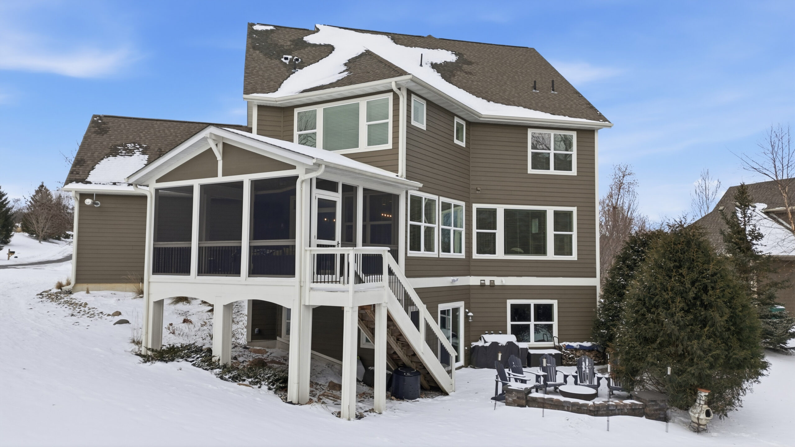 Exterior view of a house with snow-covered yard, showcasing real estate photography services.