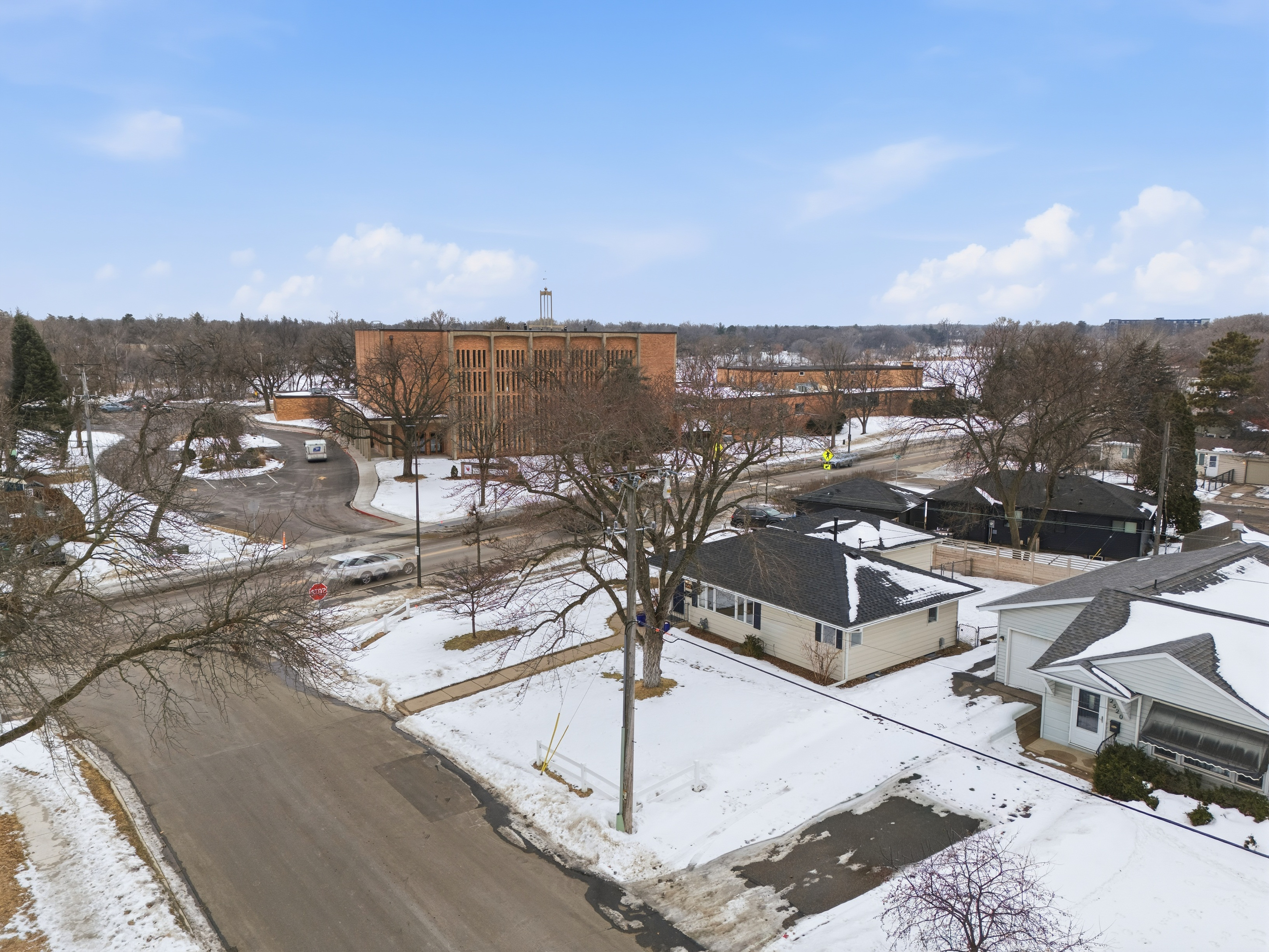 Drone photography of a snow-covered neighborhood and building showcasing Corridor Media's full home services.