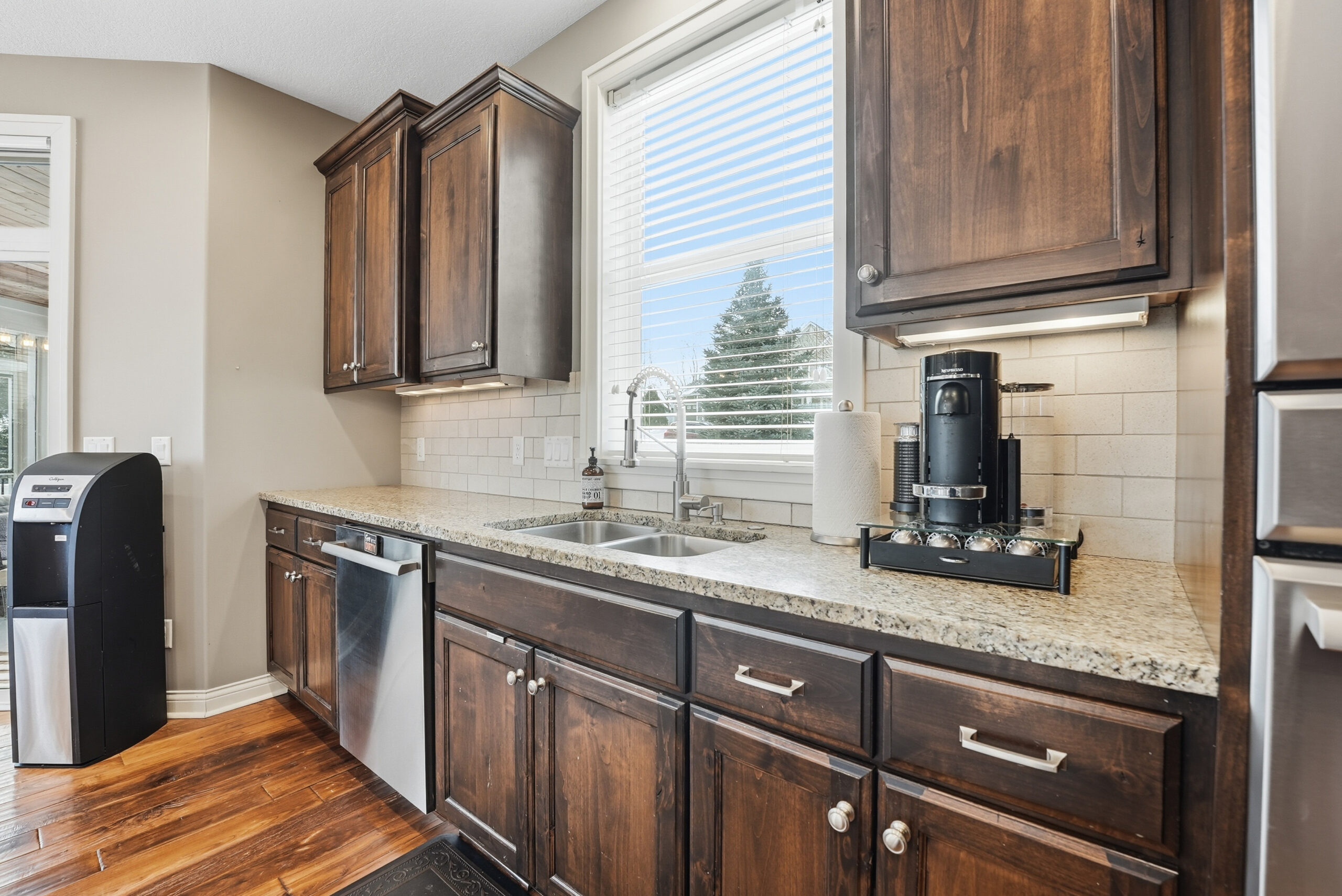 Real estate photography showcasing kitchen with dark wood cabinets and modern appliances.