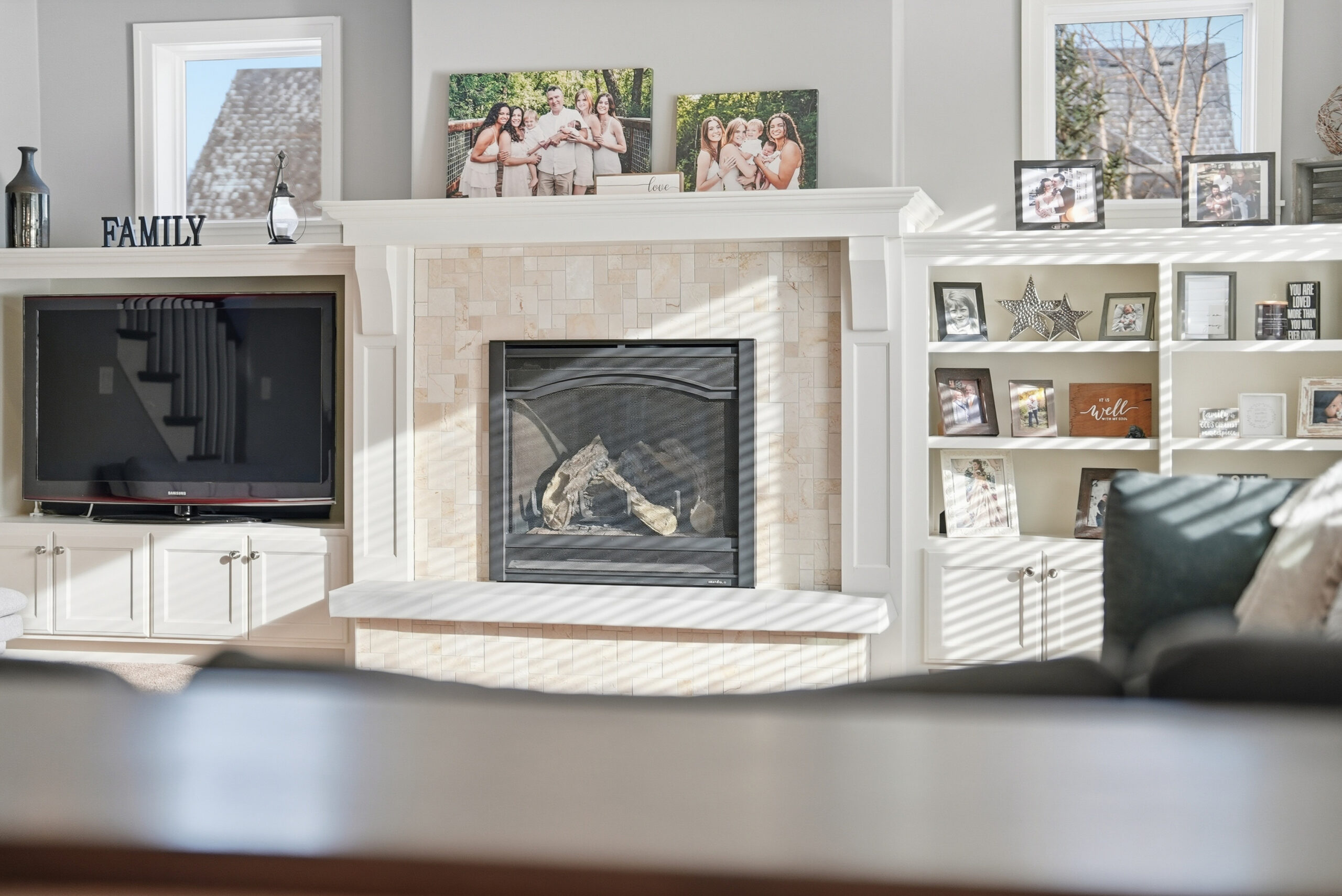 Interior real estate photography showcasing a living room with fireplace and family photos