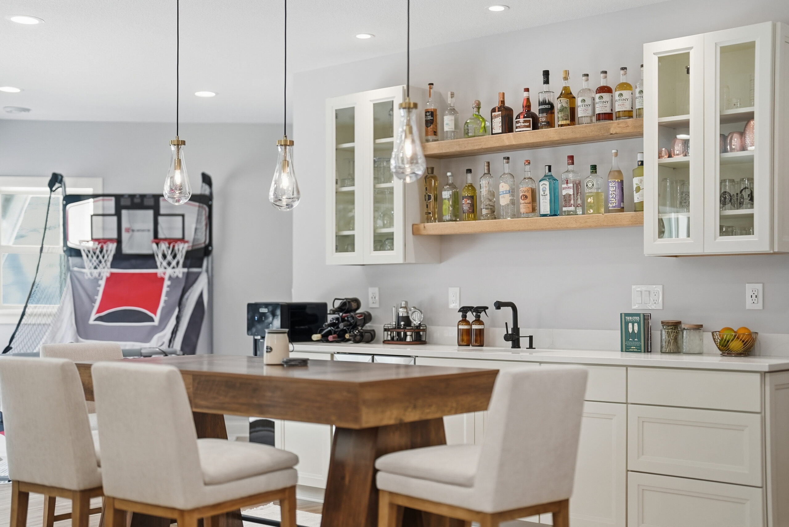 Real estate photography showcasing a stylish bar area with built-in shelving and modern lighting.