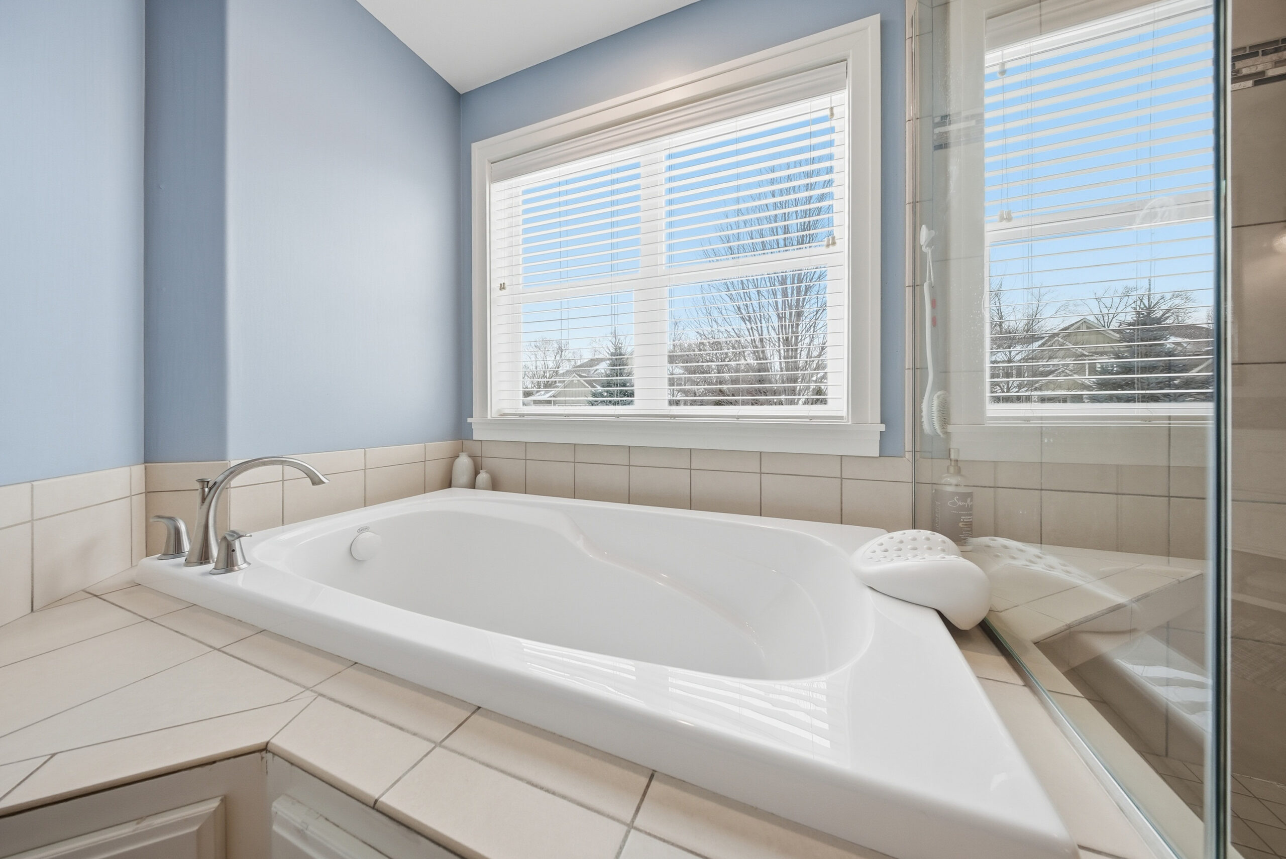 Real estate photography showcasing a bathroom with a bathtub and window by Corridor Media.