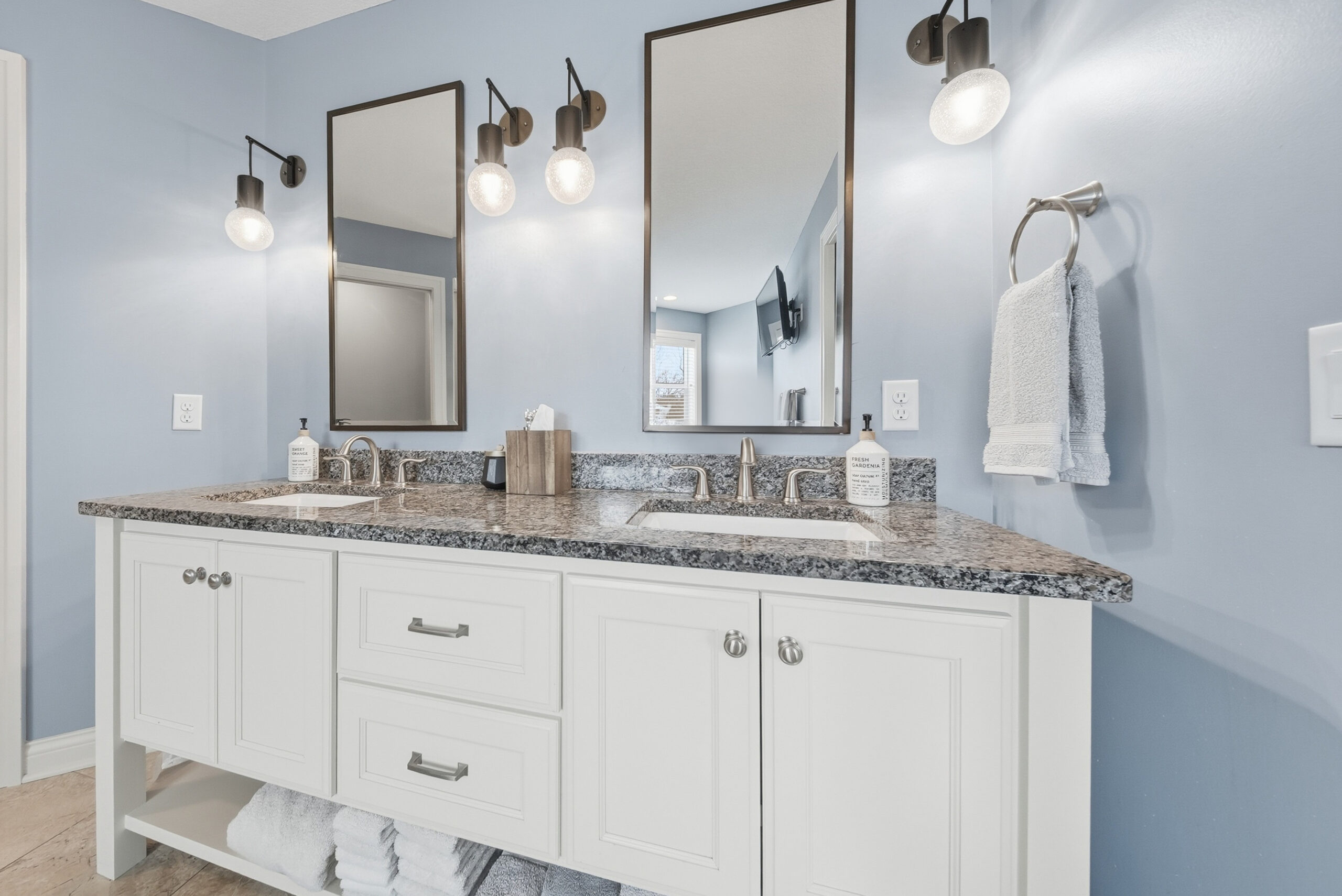 Real estate photography showcasing modern bathroom with double vanity and mirrors