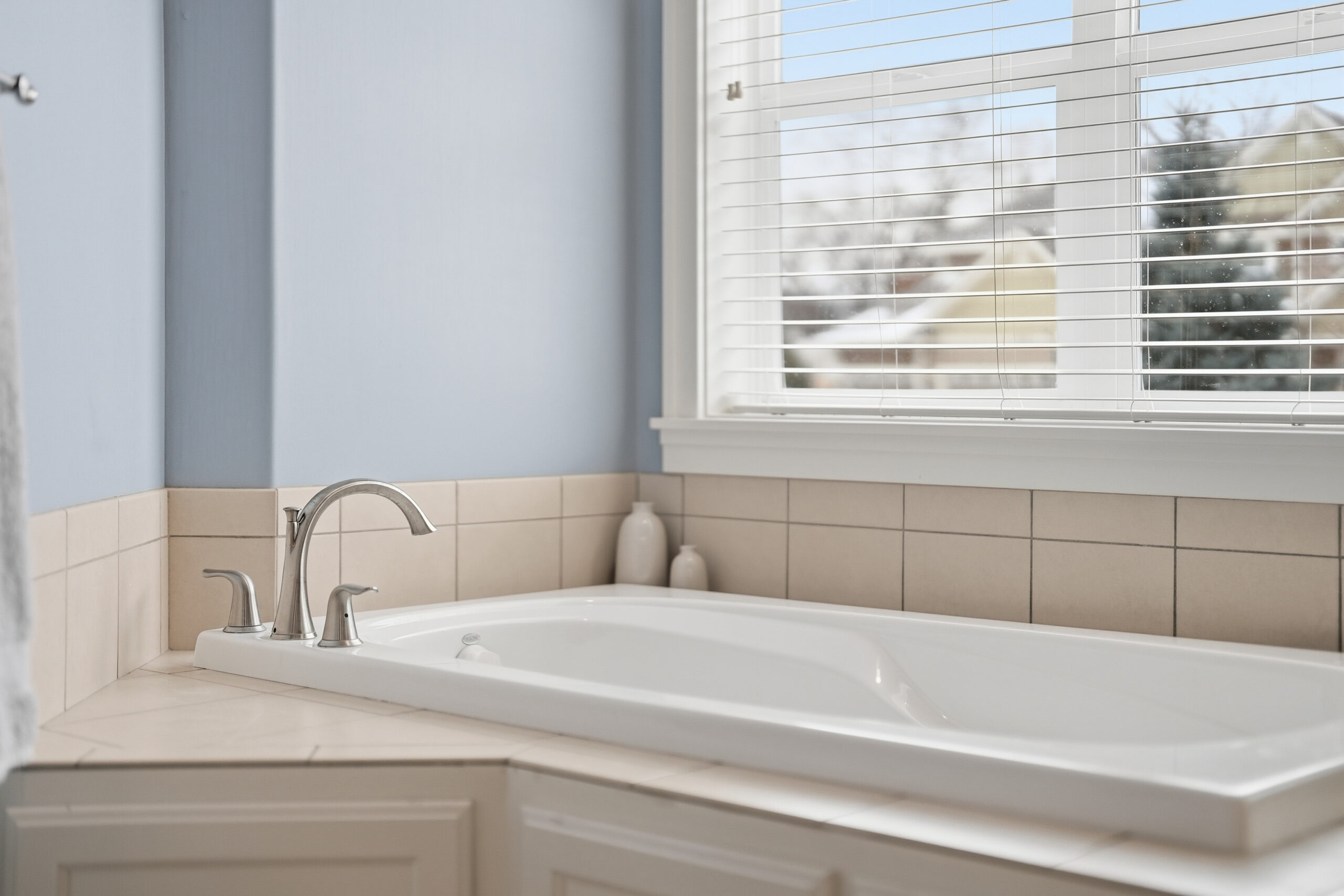 Real estate photography showcasing a bathroom with a bathtub and window.