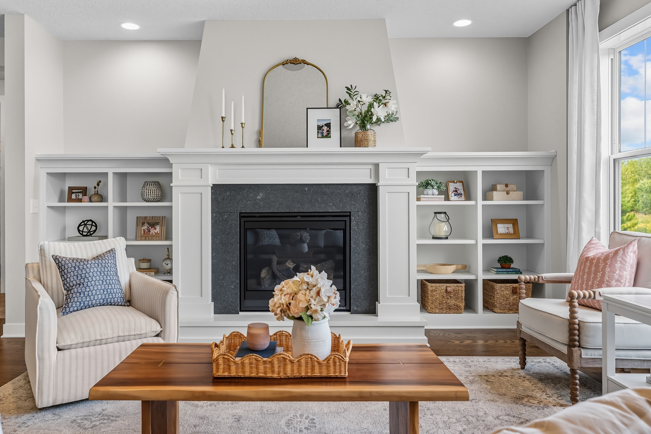 Interior photography of a modern living room with fireplace and built-in shelving for real estate media.