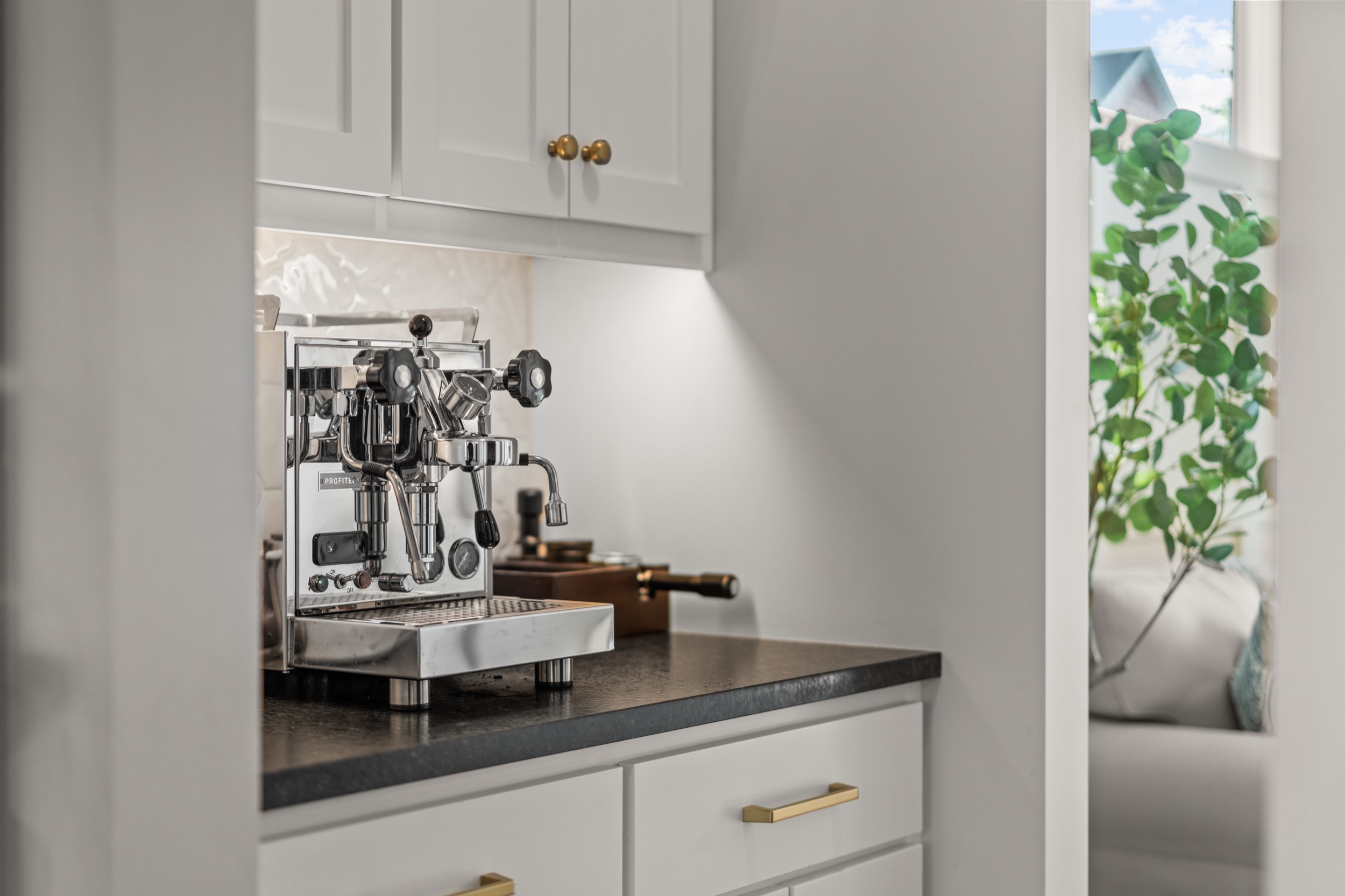 Real estate photography showcasing modern kitchen with espresso machine and stylish interior details.