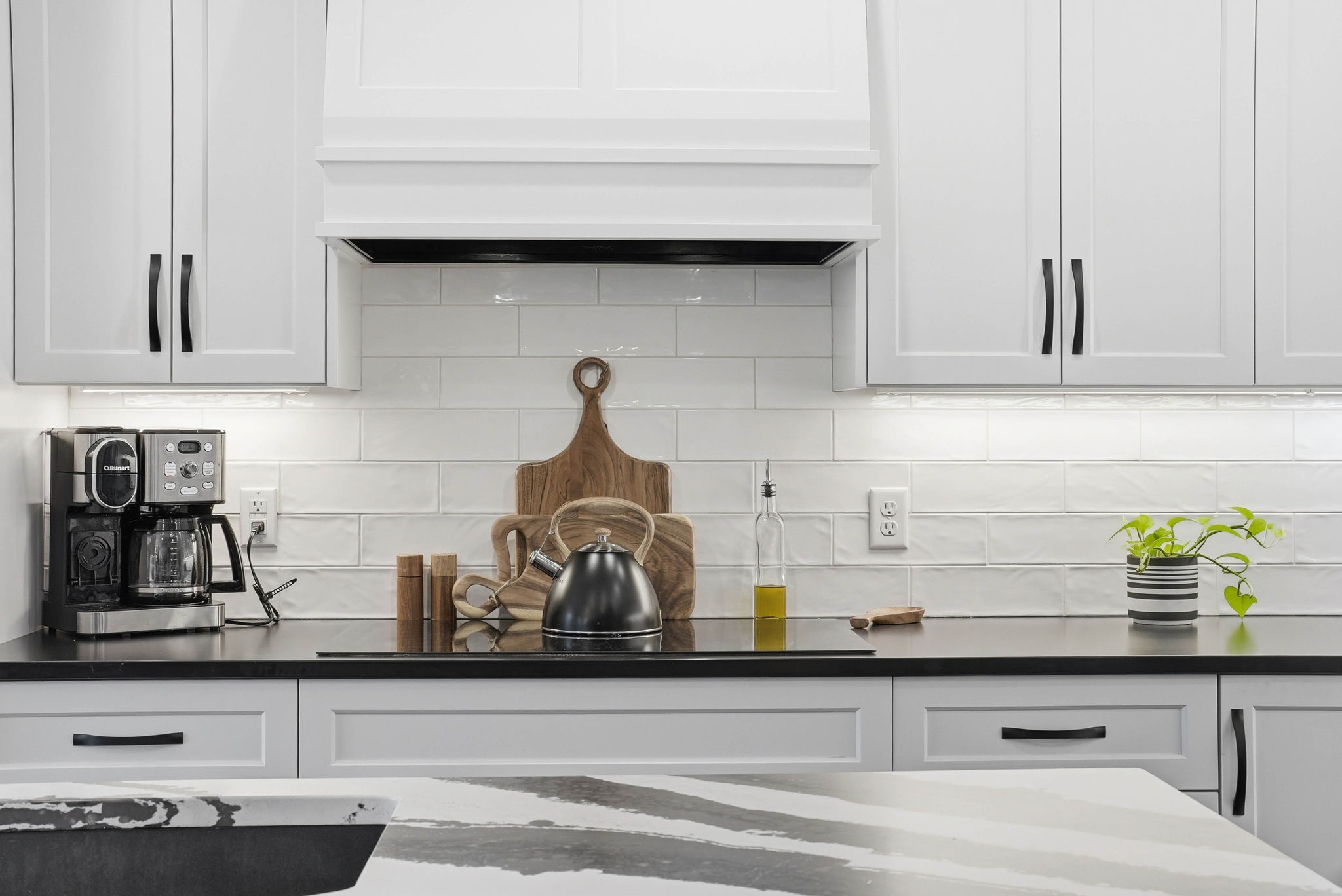 Remodeled kitchen with white cabinetry, tile backsplash, and modern appliances for Arden Hills property.