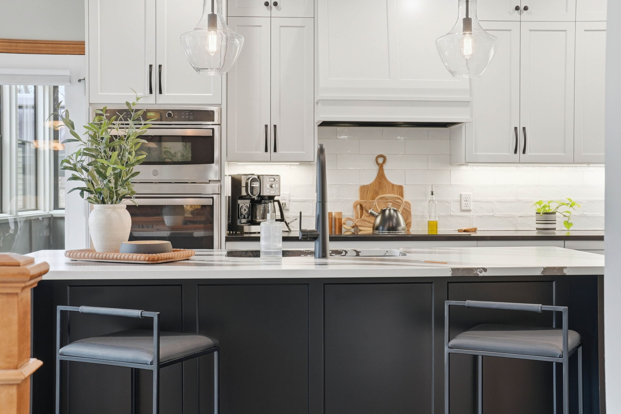 Remodeled kitchen with white cabinetry, stainless steel appliances, and marble countertops in Arden Hills home.