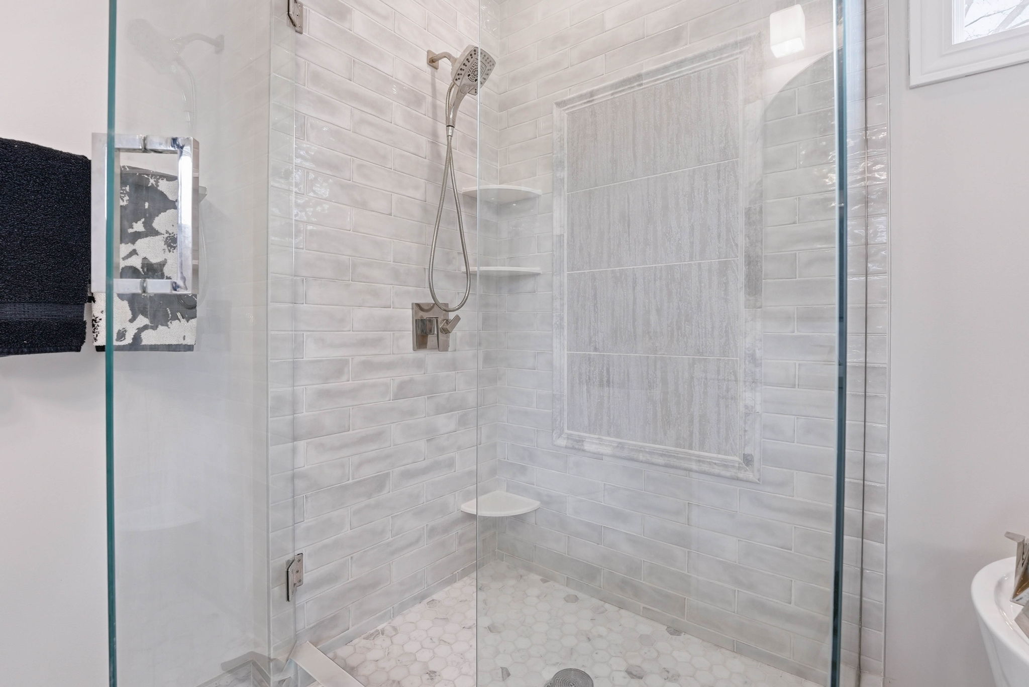 Remodeled bathroom shower with glass door and tile surround in Arden Hills home.