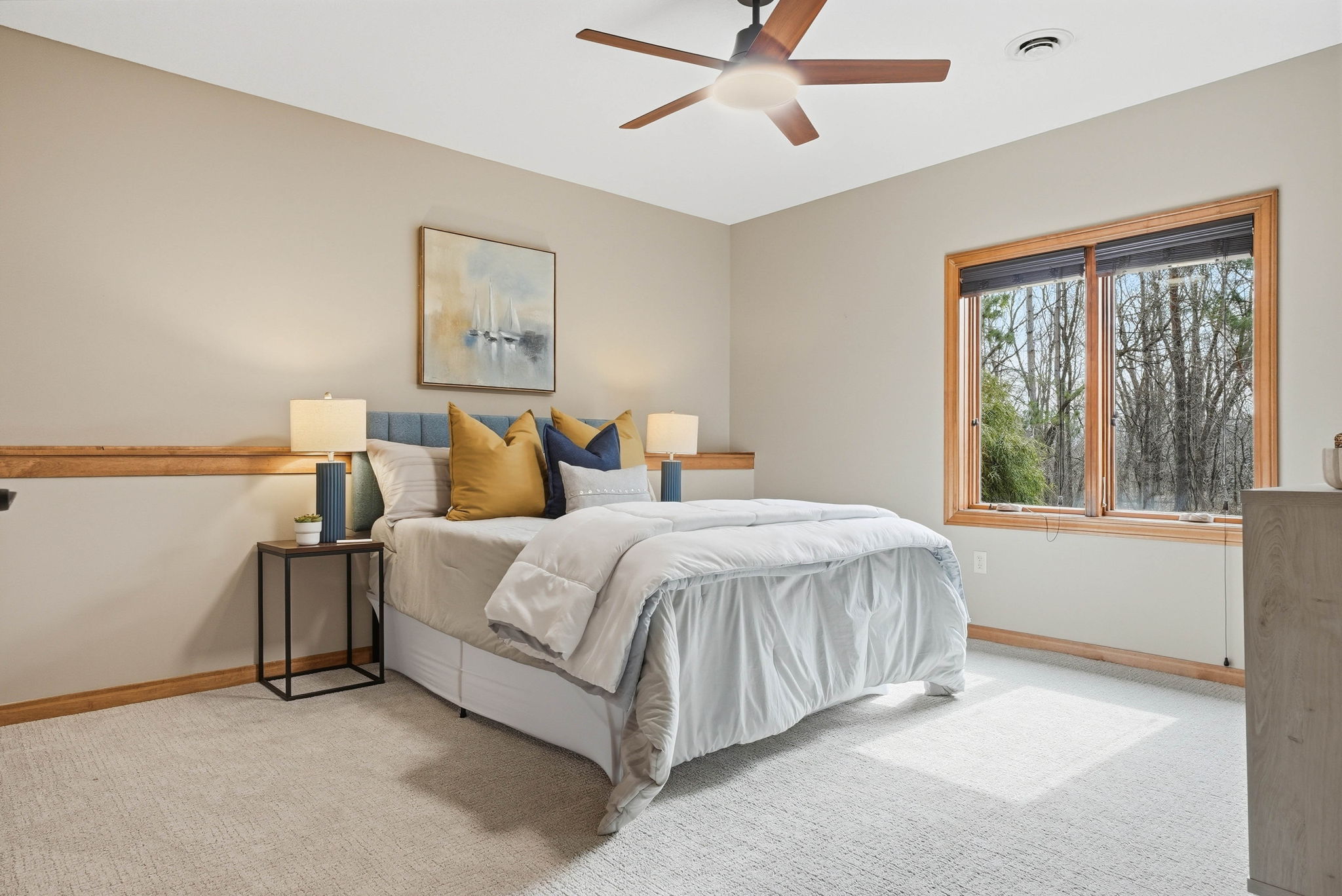Bright bedroom with hardwood floors, updated layout, and large windows overlooking a private backyard.