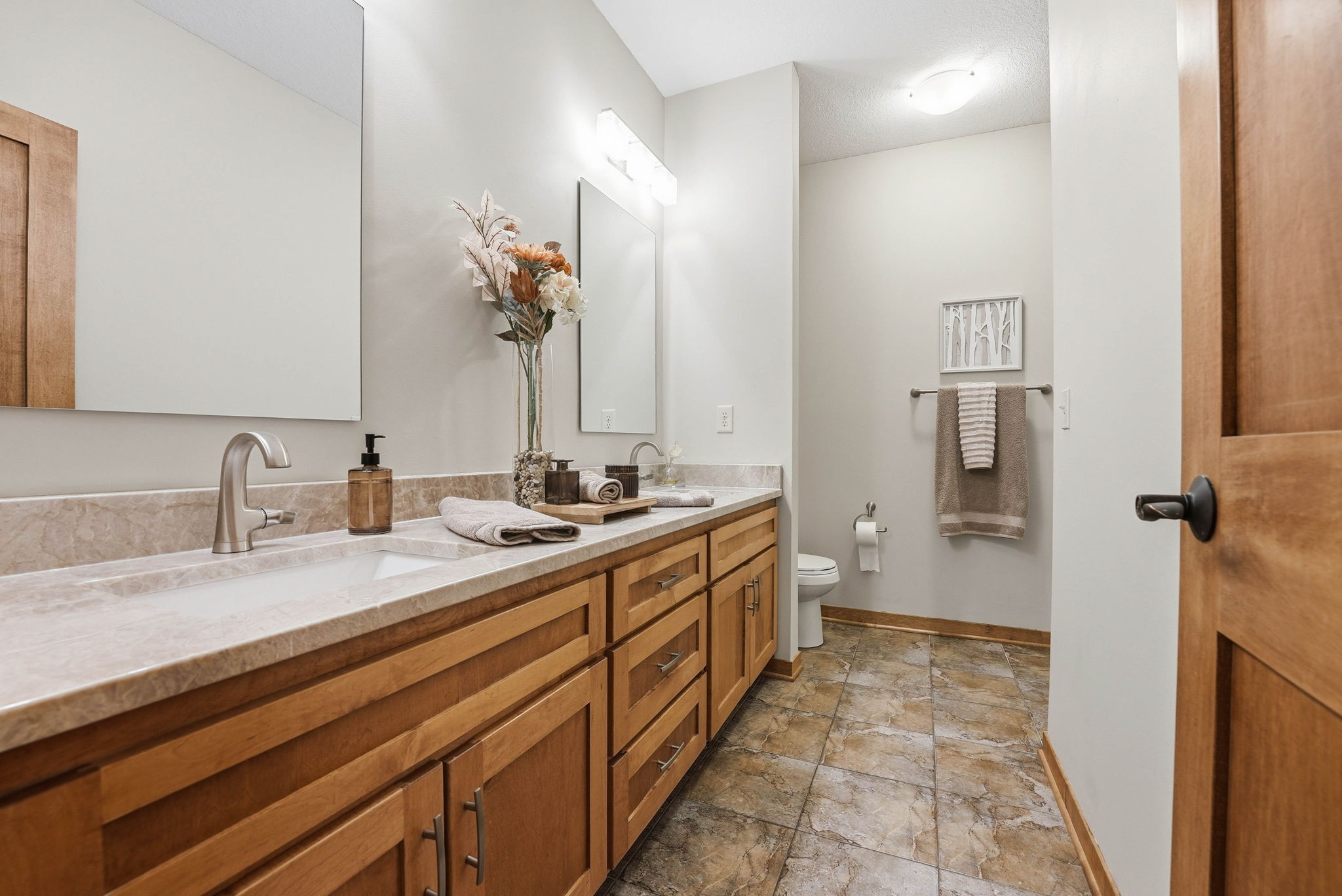 Remodeled primary bathroom with double vanity, quartz countertops, and new tile in Arden Hills home.
