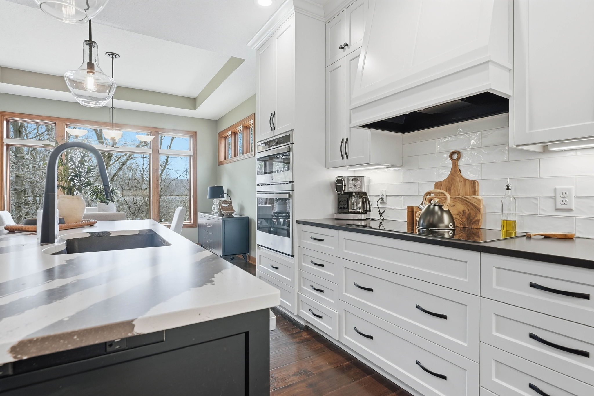 Remodeled kitchen with white cabinetry, marble countertops, and stainless steel appliances in Arden Hills home.