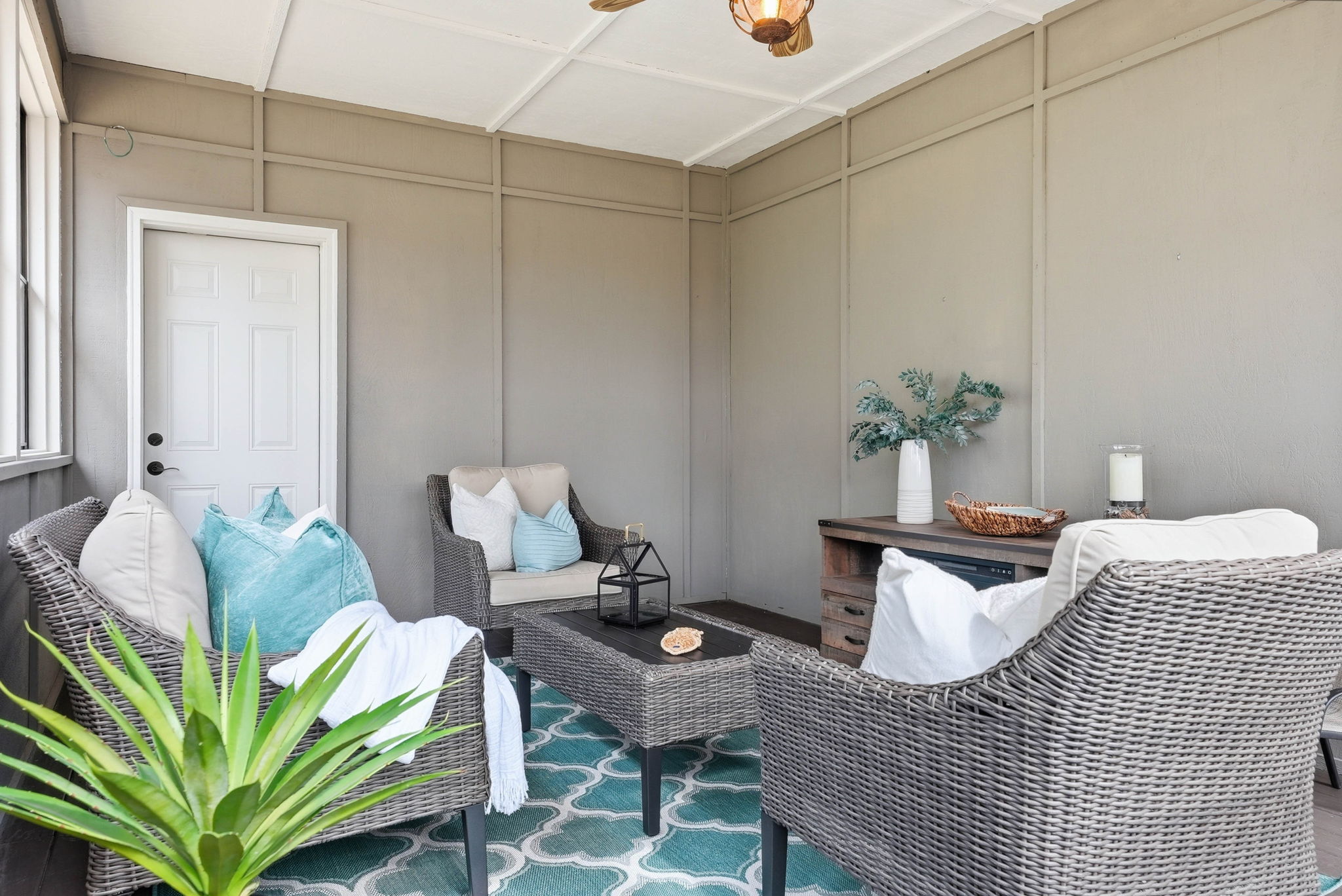 3-season porch with wicker seating and decorative accents in Arden Hills home