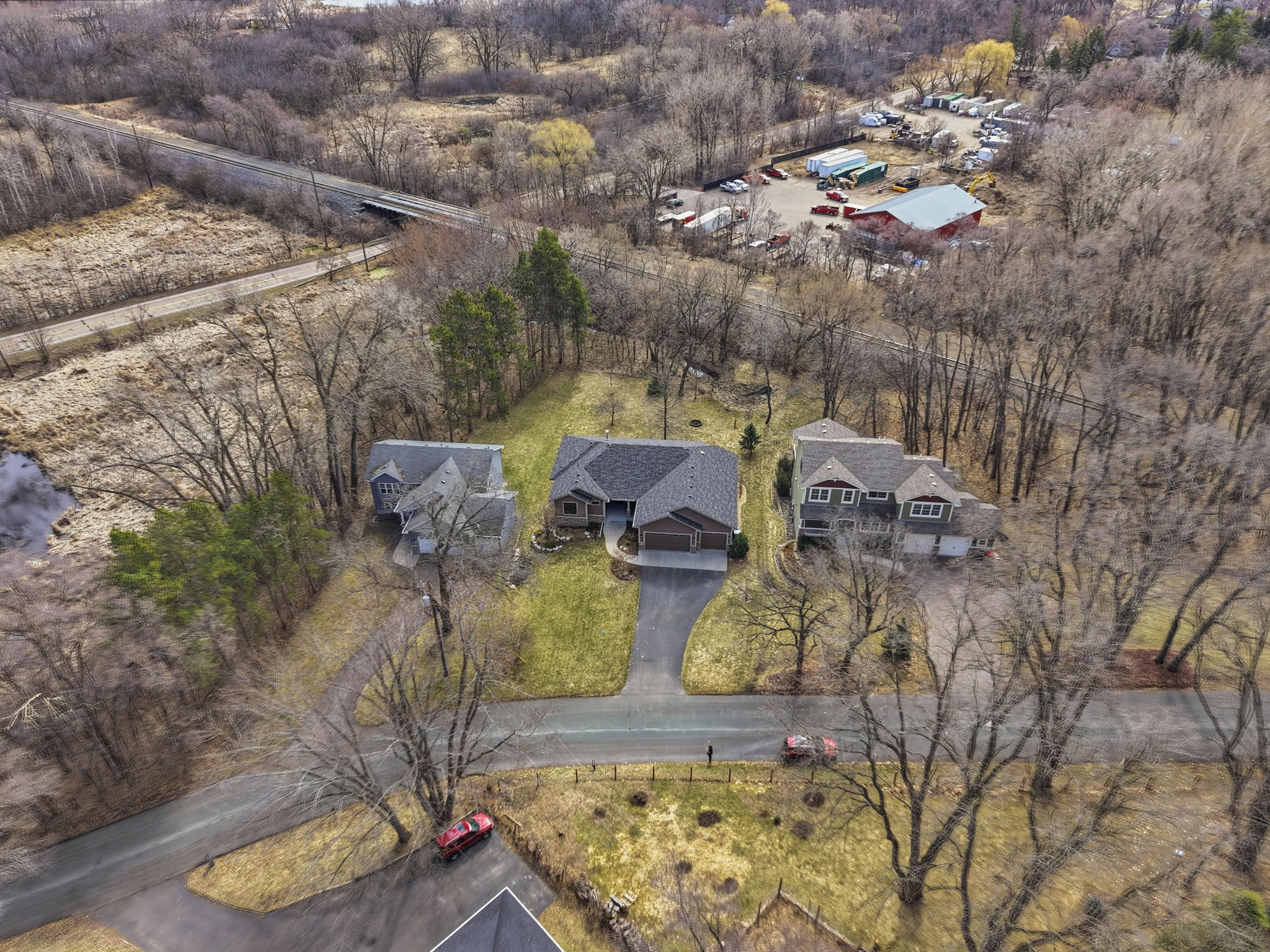 Aerial view of Arden Hills walkout rambler home and surrounding wooded landscape